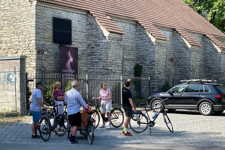 a group of people walking down a street next to a bicycle