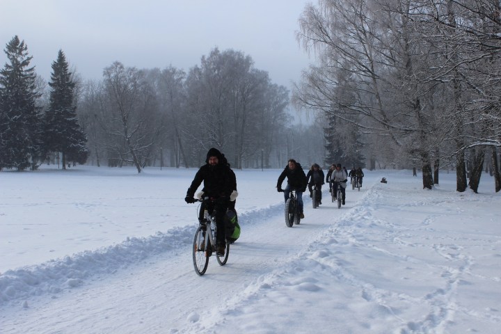 a group of people cross country cycling in the snow in Tallinn