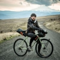 a man riding a bike down a dirt road