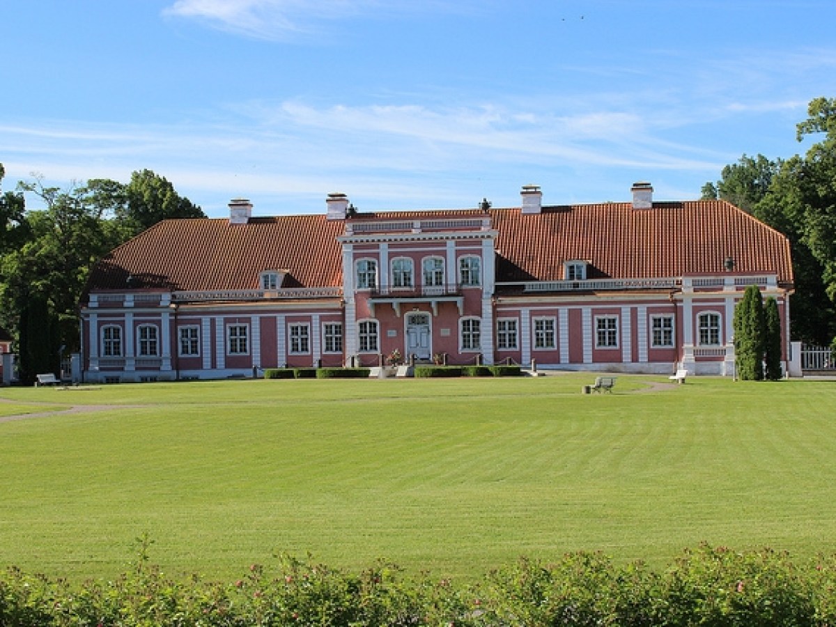 a large green field in front of a house