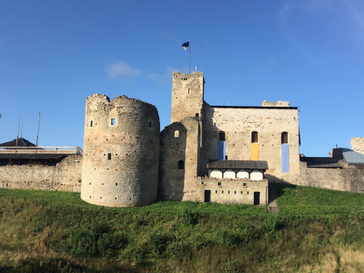 a castle on top of a grass covered field with Conisbrough Castle in the background