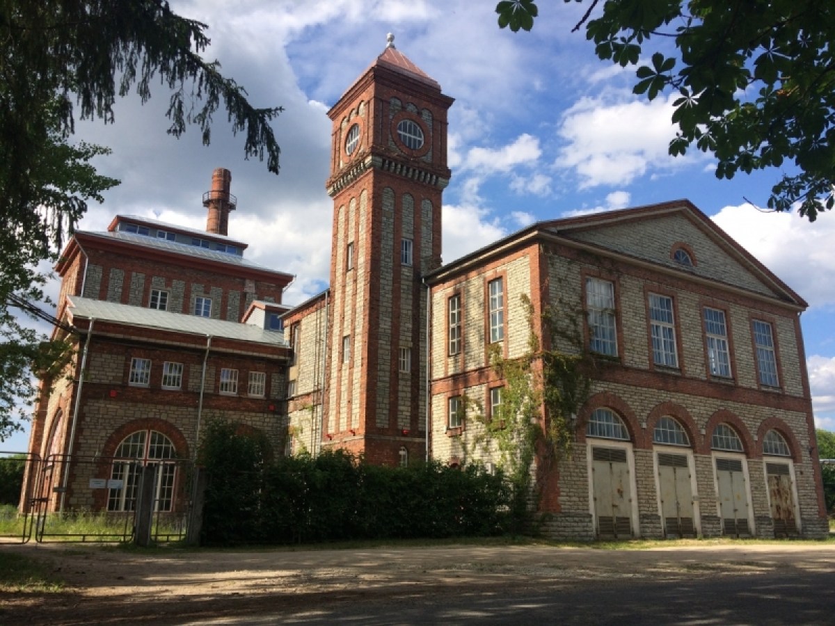 a small clock tower in front of a brick building