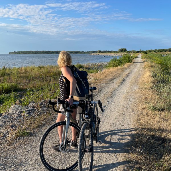 a person riding a bicycle next to a body of water
