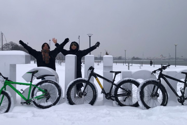 a group of men riding on the back of a bicycle